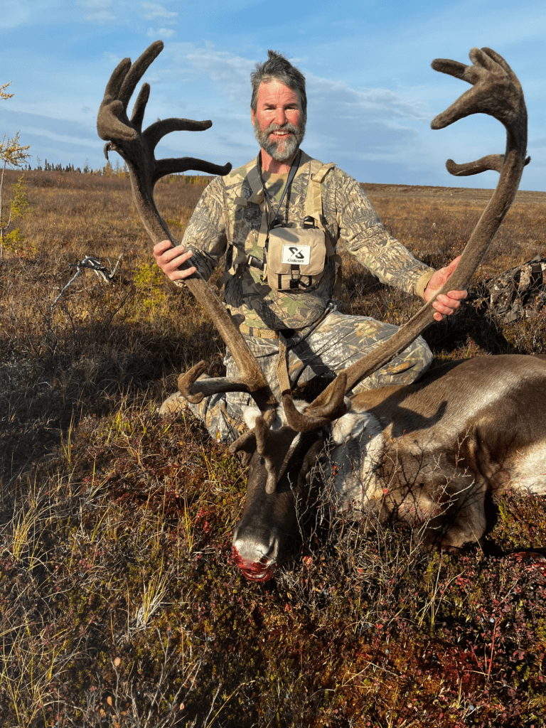 portrait of person standing over a freshly killed caribou