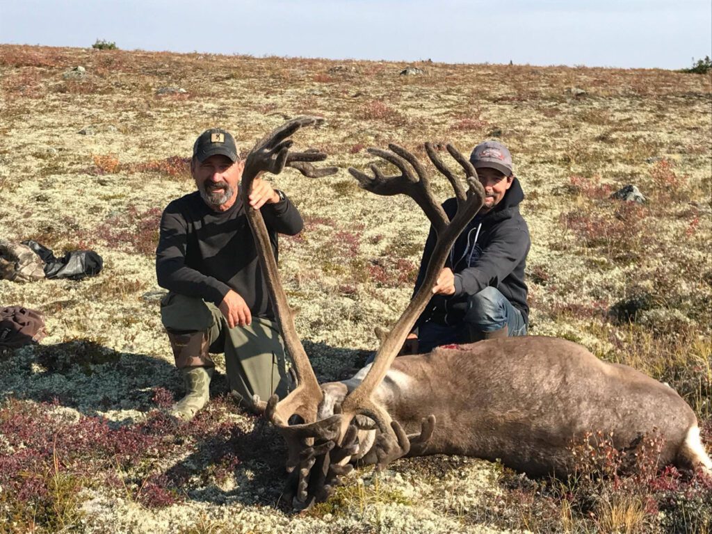 portrait of two men and their caribou