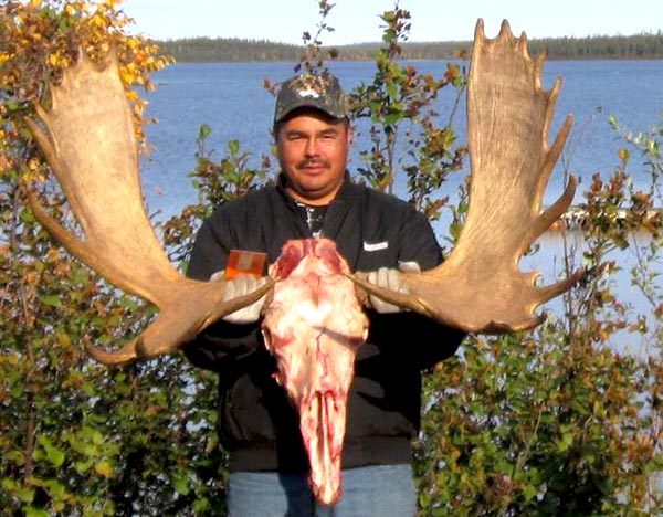 man holding a skull of a moose